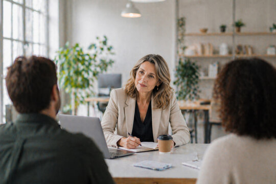 Experienced Mature Businesswoman Consulting Clients and Leading a Meeting in Modern Office