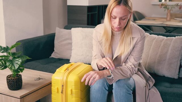 Stressed woman sit sadly at home before leaving with suitcase after an emotional breakup or separation.Woman make difficult life decision. Concept of emotional transition, heartbreak,start new chapter