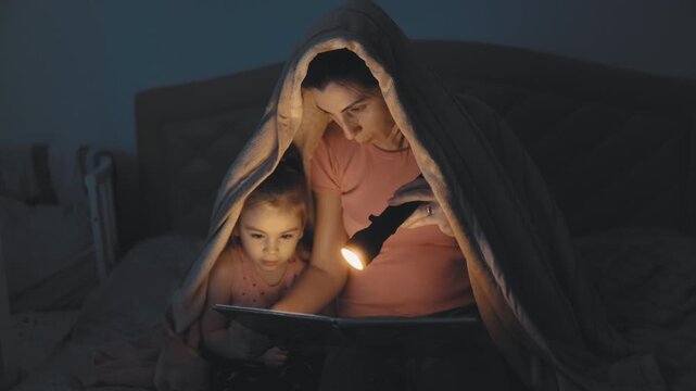 Family Moment Mother and Child Reading Under Duvet lifestyle