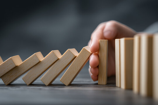 Risk and Strategy in Business, Hand stopping wooden block domino business crisis effect or risk protection concept, prevention and development to stability