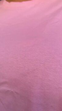 Vertical 4K video close up. Fat woman in pink t-shirt removes 3XL sticker. Concept of buying new clothes of extra large size 3 XL, shopping in mall shop, Black Friday, 11 november, sale, weight loss