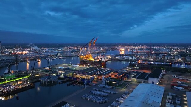 Rotterdam, Netherlands. Drone flight over industrial area with cargo ports, containers and a semi-submersible ship, heavy lifting crane. Machines designed for work at sea