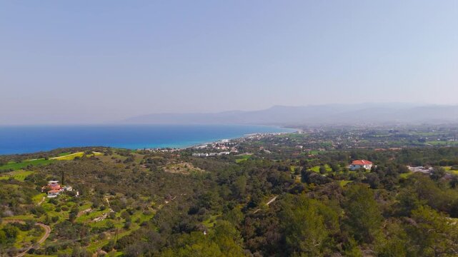 High Altitude Drone Shot of Latsi Town Coastline and Lush Hills in Cyprus