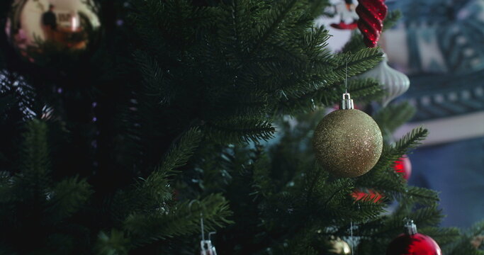 Closeup of Christmas tree with gold ornament, festive holiday decoration symbolizing warmth, tradition, and celebration of family and togetherness during winter season