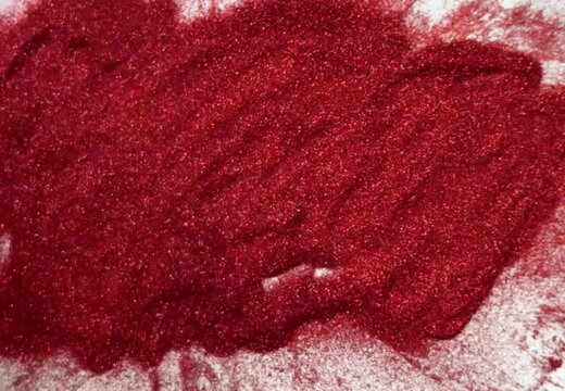 hand pours glitter and Fingers draw 2027 on red, melted glitter. Conceptual, abstract, New Year's or Christmas theme.