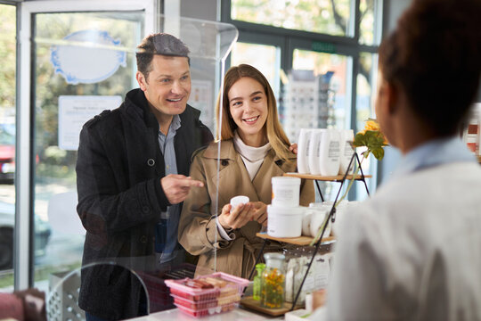 Young happy couple buying a medicine in a pharmacy