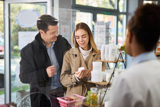 Young happy couple buying a medicine in a pharmacy