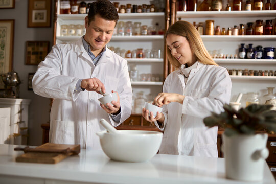 Young scientists making homeopathic medicine in a laboratory.