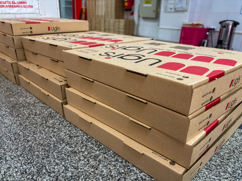 Ugi's pizza boxes stacked on a gray marble counter in Buenos Aires
