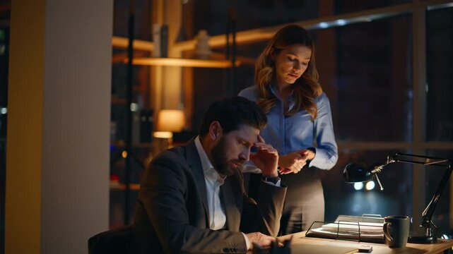 Sad two managers solving business problems working overtime in office closeup. 