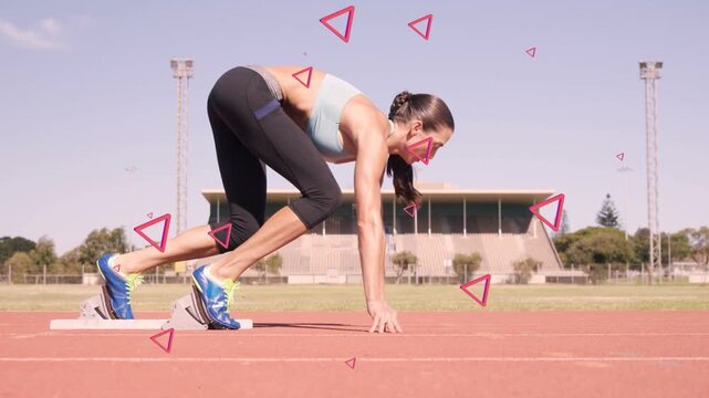 Female sprinter shifting weight and pushing off blocks, starting run with pink triangles overlaying