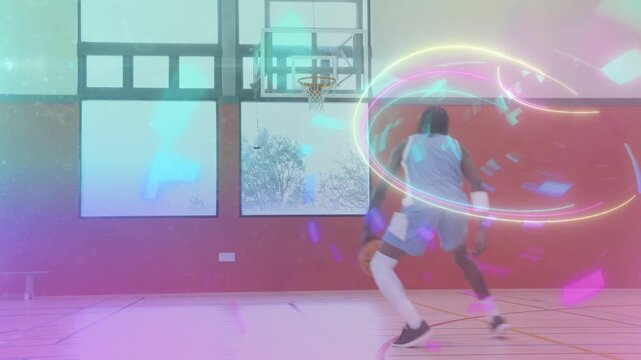 Male player entering frame dribbling toward hoop as neon swirls spiraling over him training skills