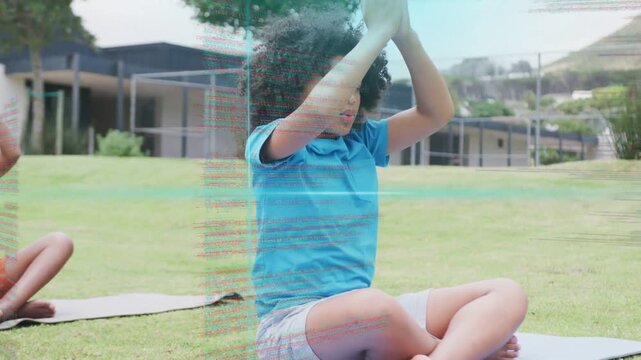 Schoolboy following breath cue lowering hands to chest on yoga mat closing eyes cam zooming overlay