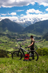 Fototapeta premium Man admiring alps view with mountain bike