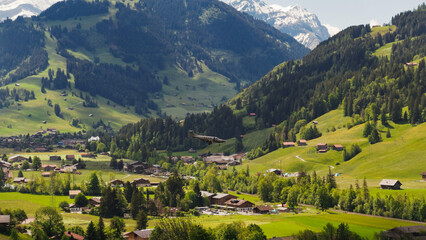 Fototapeta premium Small airplane flying over swiss alps village gstaad