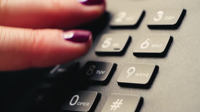 Close-up of a female hand dialing the emergency number 911 on a landline telephone. Concept of emergency call, urgent help, crisis situation, contacting rescue services, police or ambulance. High