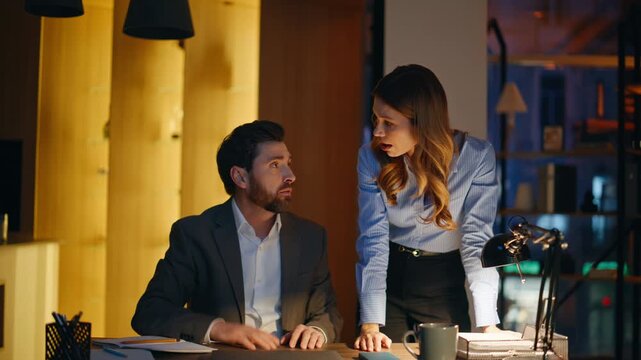 Two employees quarrelling dark workplace closeup. Stressed coworkers arguing