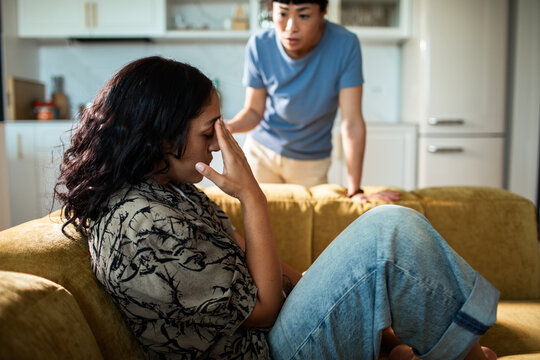 Upset person on sofa during relationship argument at home