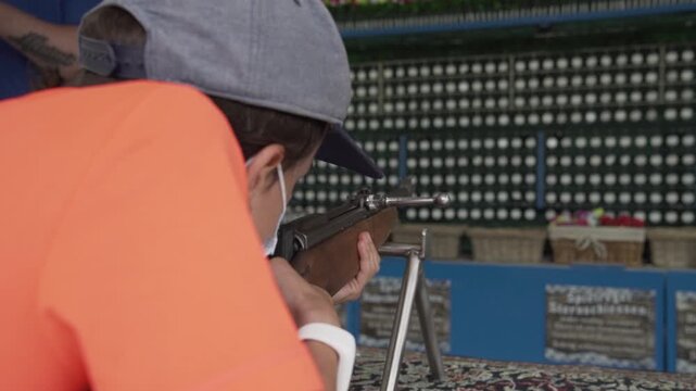 Schie&szlig;stand auf dem Jahrmarkt Person trifft Ziel mit Luftgewehr Freizeitspiel