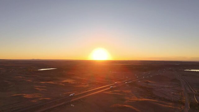 Sunrise over the Interstate 40 highway in northern Arizona, showing the many trucks driving and the vast open landscape