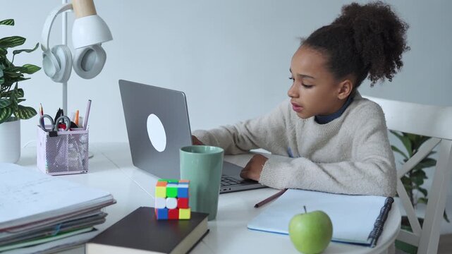 Primary middle school African American Student child girl study use laptop. Distance learning online education. School girl type at home with digital tablet computer and doing school homework.