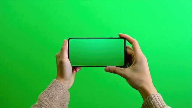 Hands Holding Smartphone with Green Screen