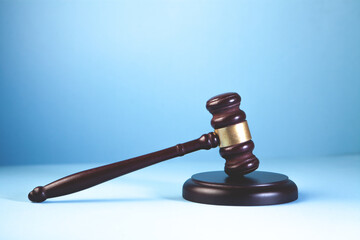 Law theme, mallet of judge, wooden gavel on blue background © Artvibe