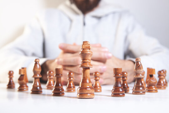 Close up of a man playing chess on a white background. Selective focus.