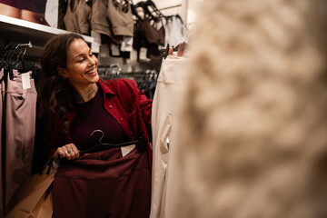 Fototapeta premium Happy woman shopping for clothes browsing retail store