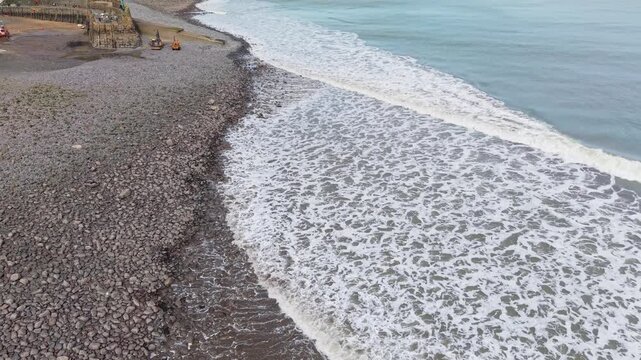 Aerial view of Clovelly Village and Harbour which is a historic 13th-century stone quay located in a privately owned, picturesque North Devon fishing village. Scenic Drone Exploration of village.