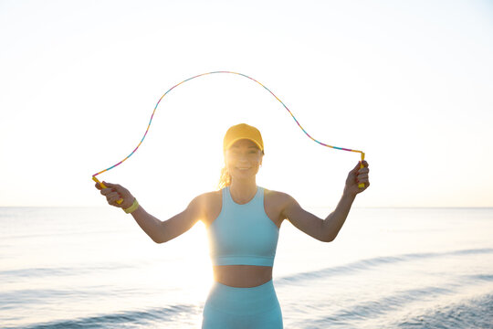 Fit woman jumping rope at the beach during summer vacation