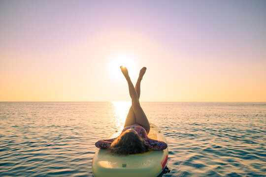 Young woman walking on sup board by the sea during summer vacation