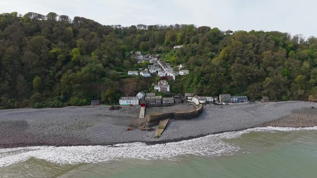 Aerial view of Clovelly Village and Harbour which is a historic 13th-century stone quay located in a privately owned, picturesque North Devon fishing village. Scenic Drone Exploration of village.