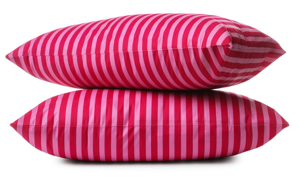 Soft pillows in pink striped pillowcases isolated on white