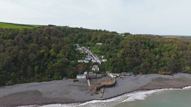 Aerial view of Clovelly Village and Harbour which is a historic 13th-century stone quay located in a privately owned, picturesque North Devon fishing village. Scenic Drone Exploration of village.