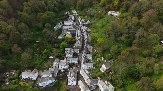 Aerial view of Clovelly Village and Harbour which is a historic 13th-century stone quay located in a privately owned, picturesque North Devon fishing village. Scenic Drone Exploration of village.