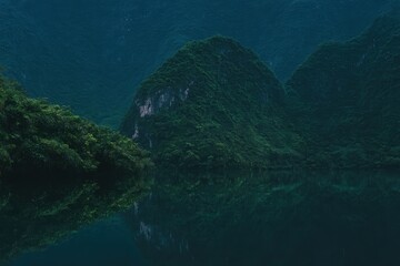 Fototapeta premium 山と水は夕暮れ近くの静かな湖に映ります