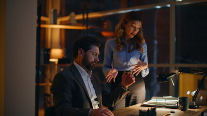 Obraz premium Sad two managers solving business problems working overtime in office closeup. 