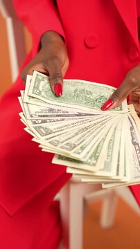 Close Up of a Confident Woman Holding a Stack of Money and Scales of Justice Symbolizing Financial Empowerment Equal Pay Day and Gender Pay Gap Awareness for Business and Wealth Concept in 4k