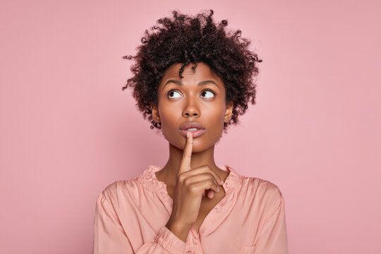 Thoughtful portrait of a young African American female in a pink backdrop