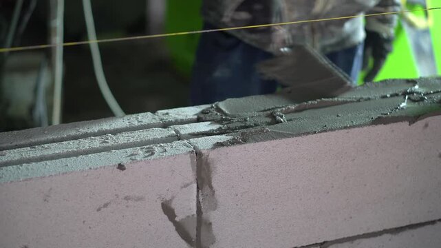 Construction Worker Applying Cement Mortar on Aerated Concrete Wall