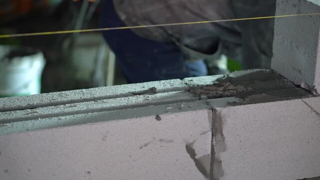 Spreading Wet Concrete on White Building Blocks