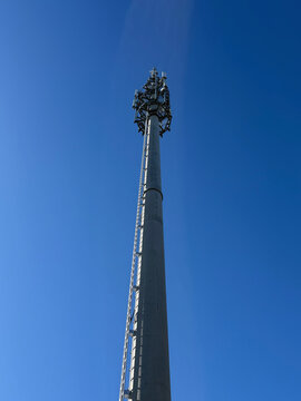 ein hoher moderner Mobilfunkmast vor blauem Himmel