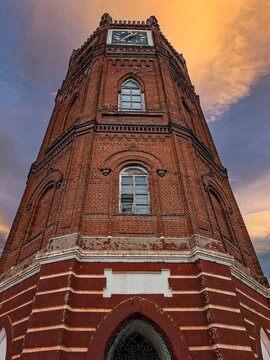 Dramatic view of Yelets Clock Tower showcasing historic architecture at sunset with gothic window details