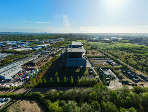 Aerial view of the Energy Recovery Facility showing the industrial complex and tall chimney stack surrounded by lush green trees and fields in Lincoln, England, United Kingdom.