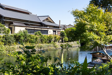 Fototapeta premium Traditional sightseeing boat sailing on river in Kyoto near Arashiyama and Togetsukyo bridge in Kyoto, Japan 
