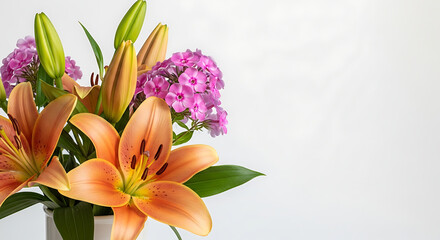 Obraz premium Orange lilies and pink phlox in vase on neutral background 