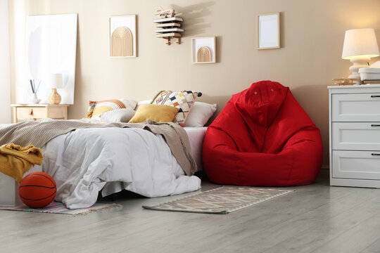 Red bean bag chair, bed and decor in bedroom