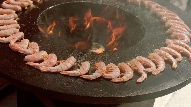 Shrimp cooking on outdoor charcoal circular grill. Seafood preparation on hot fire during street food festival. Culinary art and gourmet meal concept for dining event or party.