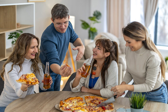 Friends gather around a table to enjoy pizza and drinks during a casual get-together in a modern living room space